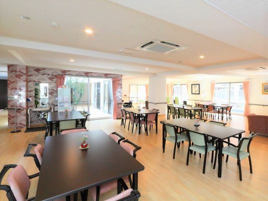 四人掛けのテーブルと椅子が離れて配置されている施設内のリビングスペース