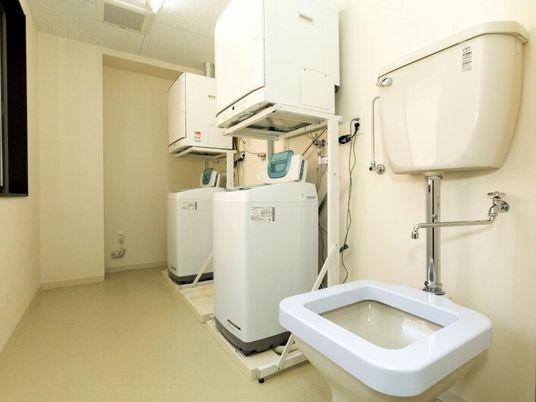 乾燥機付き洗濯機が複数台並んでいる施設内のランドリースペース