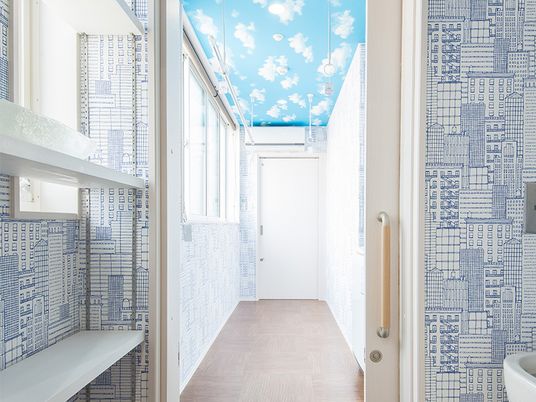青空を模した天井とおしゃれな質感の壁紙が写っているスペース