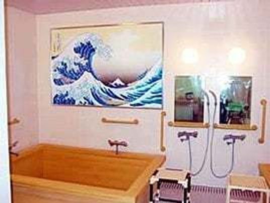 絵画のようなものが掲げられている浴室。シャワーチェアや手すりがある高齢者用の浴室