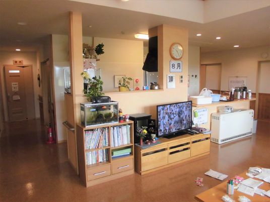 本棚や水槽、テレビが置かれた木のぬくもりを感じられる館内。温かい照明。