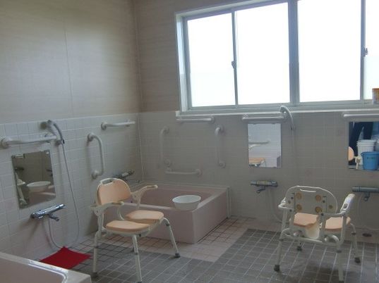 個浴が複数設置された広い浴室。シャワーチェアや手すりも完備されている。