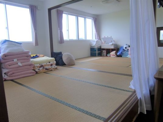 畳敷きの広いお昼寝スペース。窓の近くには毛布や布団がたたまれている。