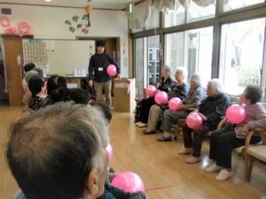 施設内でレクリエーションを楽しんでいる様子。風船を使って運動している様子