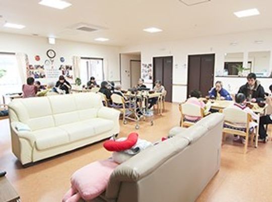 ソファが二組と椅子・テーブルが置いてある施設内のリビングルーム