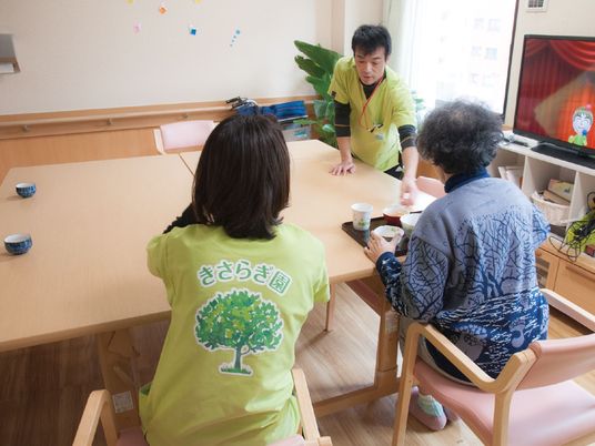 医師とスタッフが入居者に接している様子。食事の時の一場面