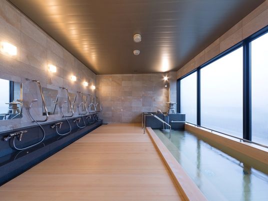 木製風の床が見える浴室内の様子。桐のような雰囲気のある浴槽がある浴室
