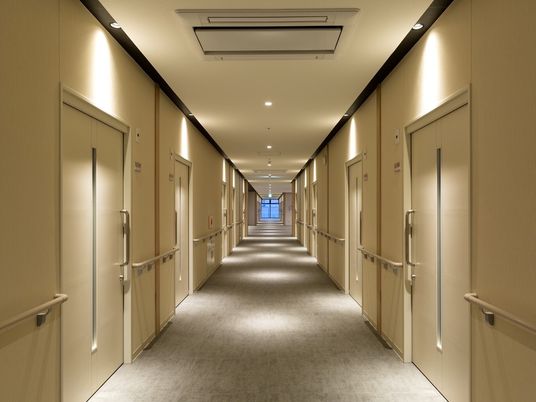 個室のドアが並んでいる施設の様子。やわらかい照明がホテル風