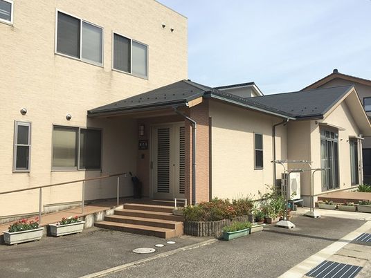 階段とスロープがついている施設の入り口。普通の住宅風のデザイン