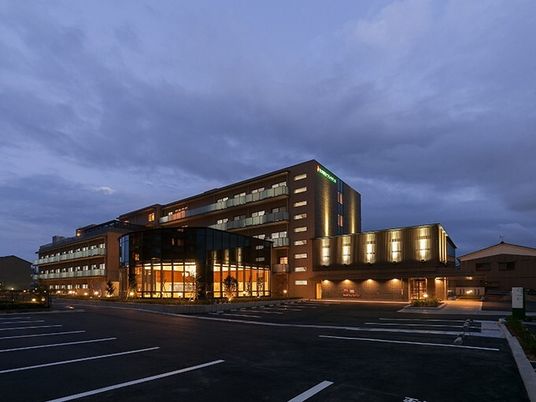 夕暮れ時にあたりが暗くなり、建物のシルエットが浮かび上がっている。館内には明かりが灯っている。