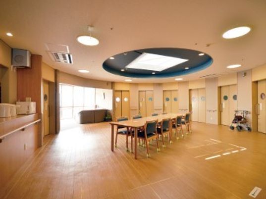 大きなダイニングテーブルが中央に置かれたスペース。居室のドアも並んでいる。