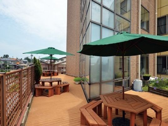 パラソル付きのテーブルセットや園芸スペースがあるウッドデッキ。