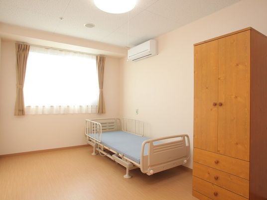 段差のない居室にはエアコンが設置され、介護用ベッドや収納タンスもある。
