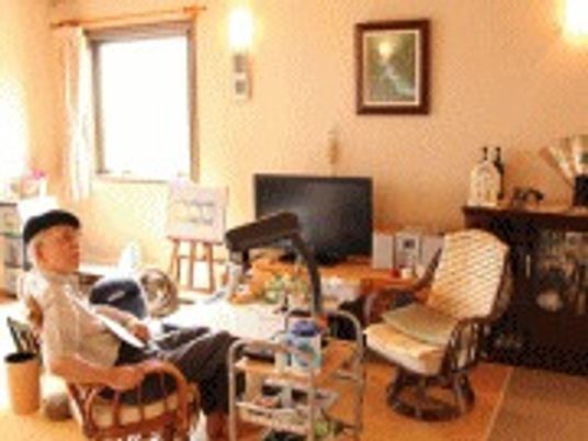 壁に絵画や照明がかけられた施設内の居室の様子。ベッドやいすが置いてある