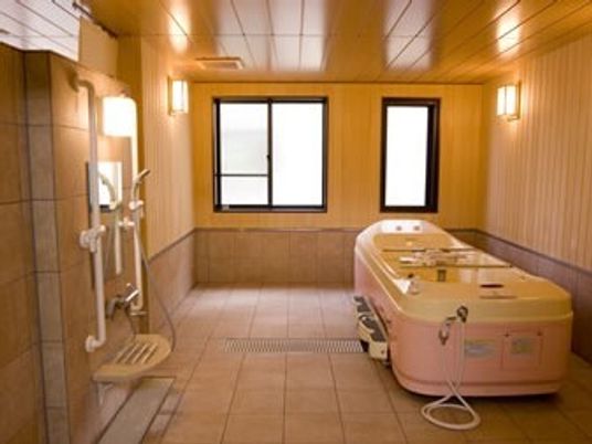 寝たまま入浴可能な機械浴を設置した広い浴室にはシャワーも付いている。手すりもあり、窓も複数ある。