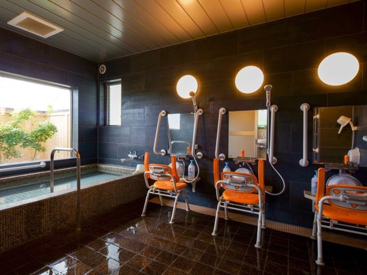 大きな浴槽が設置された大浴場からは和風庭園を眺めることができ、シャワーチェアが設置されたシャワースペースもある。