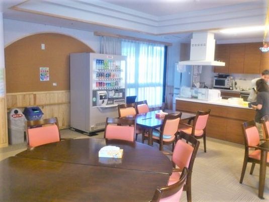 丸テーブルにいすが数脚分並べられている様子。奥のほうに自動販売機が置いてある