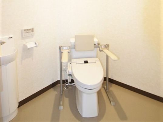 便器の両側に手すりが配置されているトイレの様子。広めのスペース
