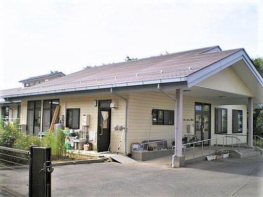 一軒家のような雰囲気のあるグループホームの外観写真。平屋建ての建物が広い敷地に建っている様子