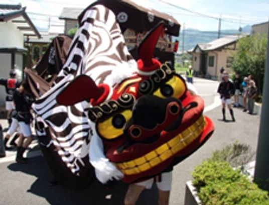 こちらを向いている獅子舞の様子が写っている。家庭を報もしている様子