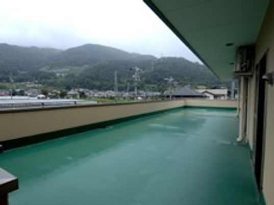 施設内のベランダの様子。外は曇り空で遠くに山が写っている