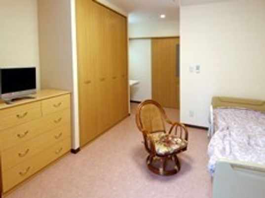 いすや収納、テレビが映っている部屋。一人用の部屋であることが分かる