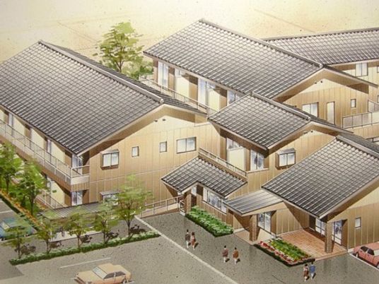 2階建ての瓦屋根の家が集合している。駐車場や中庭もある。