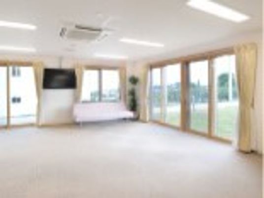 大きな壁掛けテレビが設置されている共有スペースには窓がたくさんついていて、家具や家電はない。