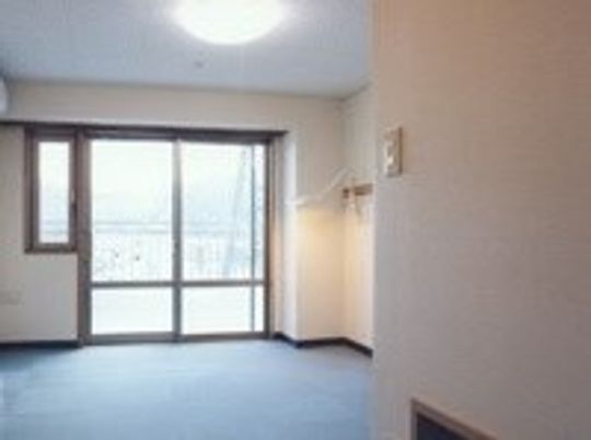 広めの空間の向こう側にベランダがあり、景色が見えている。部屋の一角を写した写真