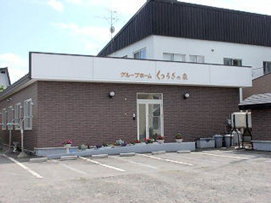 ホーム名が屋根に書かれ、花が植えられたプランターがホームを囲み、広い駐車場も付いている。