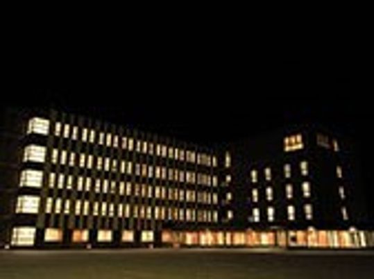 建物の外観、夜の風景。周辺は真っ暗で、建物のライトだけが浮かび上がっている。