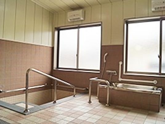 右手に機械浴、左手に手すりが付いた埋め込み式の浴槽がある。
