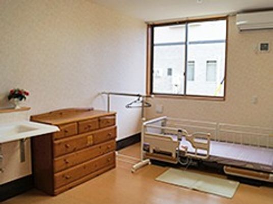 段差のない居室には洗面所やエアコンが設置され、介護用ベッドや収納タンスもある。