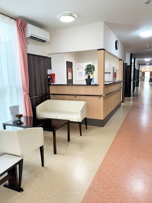 スタッフステーションが奥にある施設内の一角。ソファとテーブルが置いてあるリラックススペース