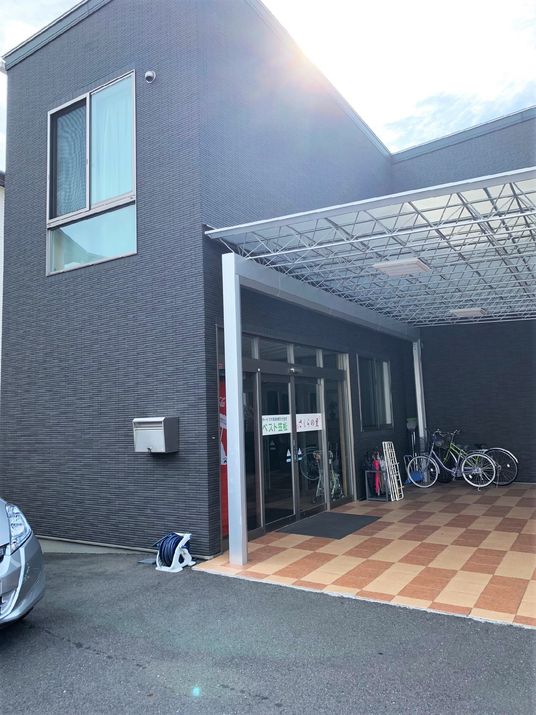 シックな黒の外観が印象的な施設の写真。手前にあるエントランスはバリアフリー構造