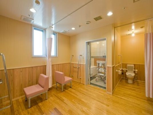カーテンで開け閉めするタイプのトイレが右側に、左側には浴室があり、脱衣所にはカーテンが設置されている。
