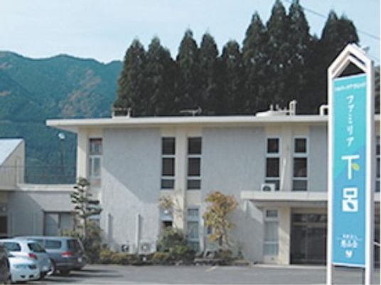 『ファミリア下呂』の外観。白を基調とした明るい外観で、水色の大きな看板が目を引く。
