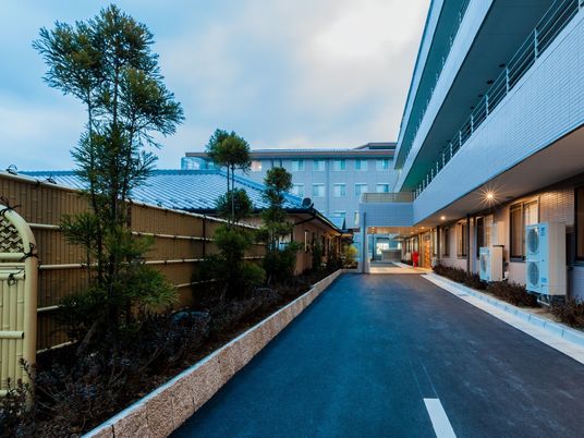 施設の外にある車が走れる道路と植込みの様子。日本庭園風にまとめられている