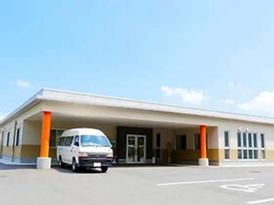 福祉車両が止まっている平屋建ての建物の玄関には大きな屋根が付いている。