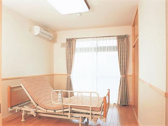 ベッドやエアコンが置いてある広めのワンルームタイプの部屋