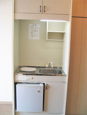 居室内のみにキッチン、冷蔵庫の様子。電子調理器と流し台があるタイプ