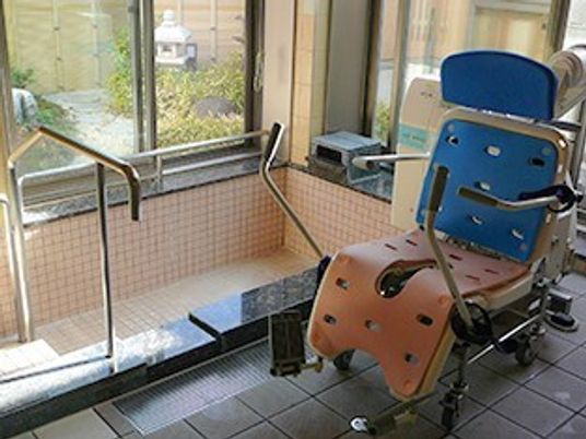 リフトを使用した大きな浴槽内に入ることができる。浴室の窓の外には日本庭園がある。