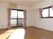 大小の窓が付いた明るい雰囲気のフローリングの部屋には、エアコンが付き、家具はまだ置かれていない。
