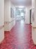 オールバリアフリーの床と手すり付きの壁を写した写真。派手な色合いの廊下