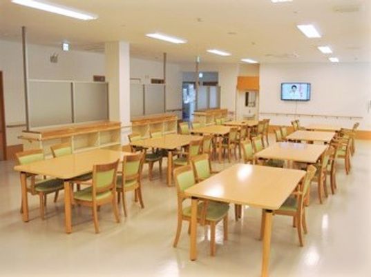 四人掛けのテーブルと椅子が複数組並んでいる施設内の食堂の様子