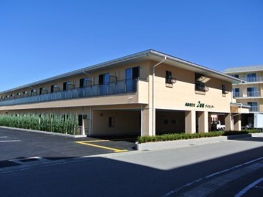 鉄骨造２階建ての建物の写真。日当たりが良い場所にあるサービス付き住宅の様子
