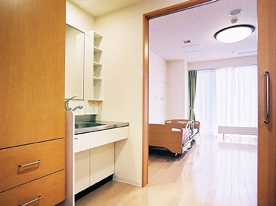 キッチンがついたワンルームタイプの部屋。照明とカーテンがついている様子