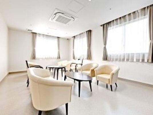ゆったりと大きなソファセットが置いてある談話室内の様子。窓がある明るい部屋