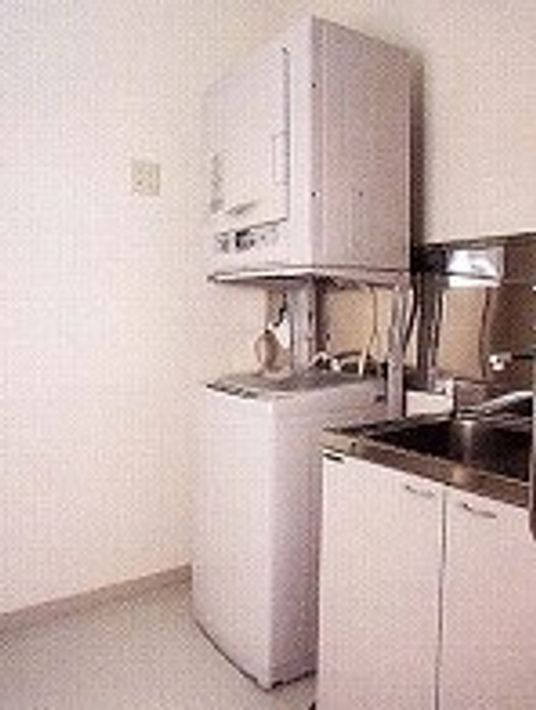 洗濯機の上に乾燥機があり、その横に洗い場がある。