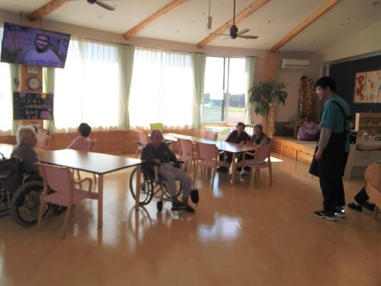 車いすでもスムーズに動ける広さのリビングスペース。スタッフと高齢者が話している様子